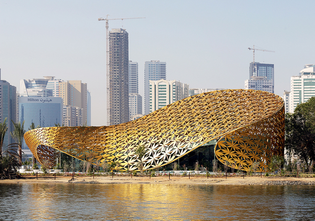 Butterfly House ... surrounded by two intertwining, curving free-form roof surfaces, covered in golden flowers.